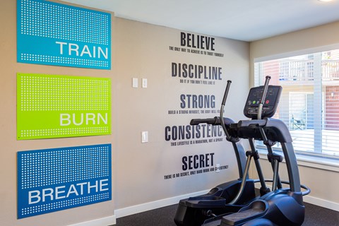a workout room with a treadmill and motivational signs on the wall
